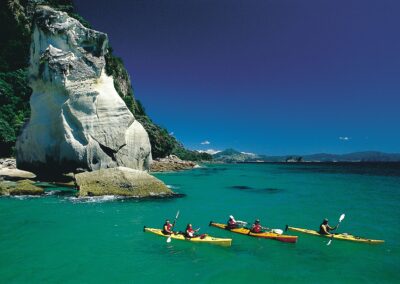 kayaks on gren blue water with lime stone cliffs