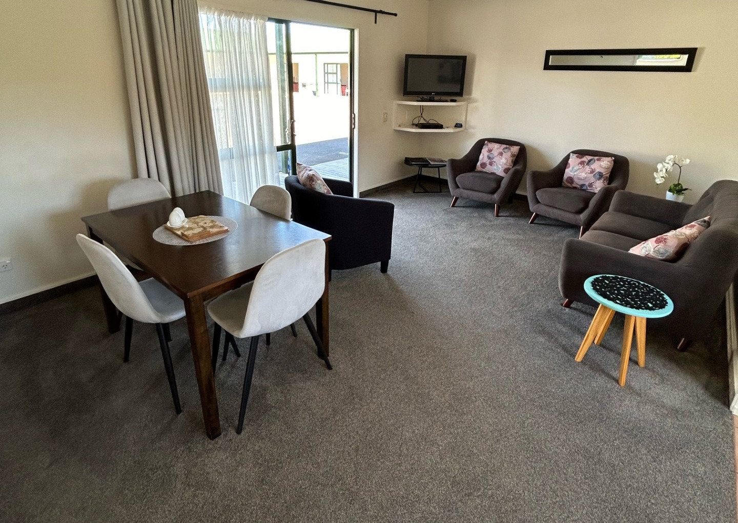 motel style lounge with table and chairs and couch in backhground