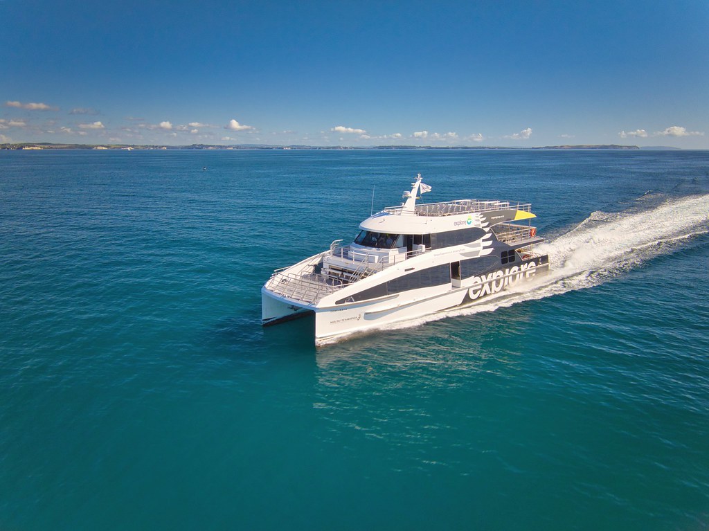 white catamaran ferry zooming along on blue ocean